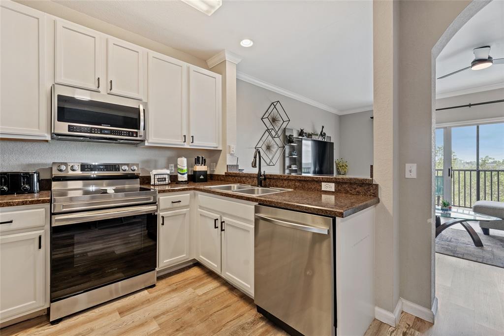 14200 Avalon Road, Unit 409 Winter Garden, FL 34787 - Photo 11 of 33 a kitchen with stainless steel appliances granite countertop a sink and a stove top oven