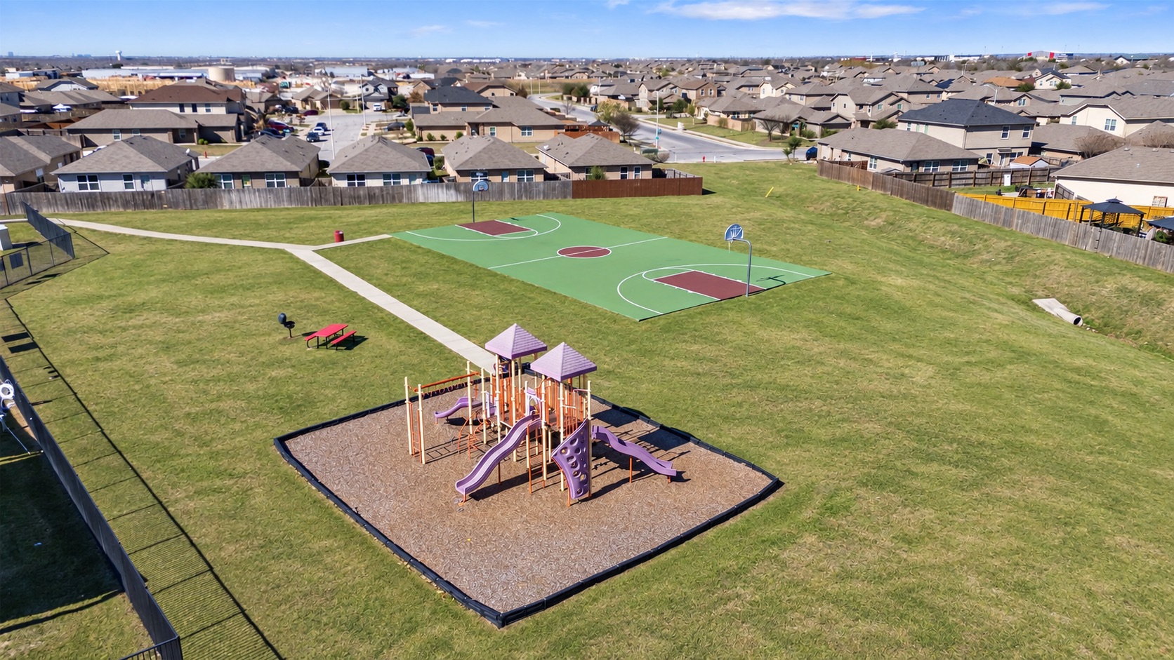 15011 Tuff Rd Manor Manor, TX 78653 - Photo 35 of 37 Neighborhood park with a children's playground, full-size outdoor basketball court, picnic tables, and walking paths.