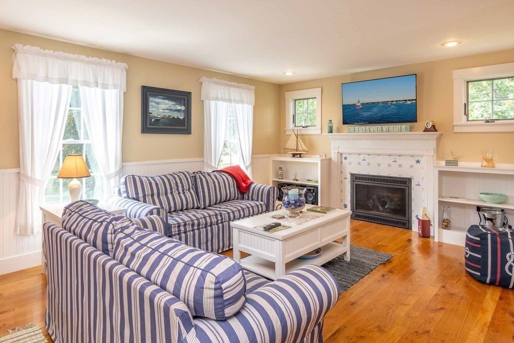 196 Springhill Road Tisbury, MA 02568 - Photo 4 of 32 a living room with couches a fireplace and a kitchen view