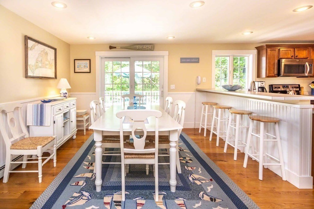 196 Springhill Road Tisbury, MA 02568 - Photo 7 of 32 a dining room with wooden floor and large windows