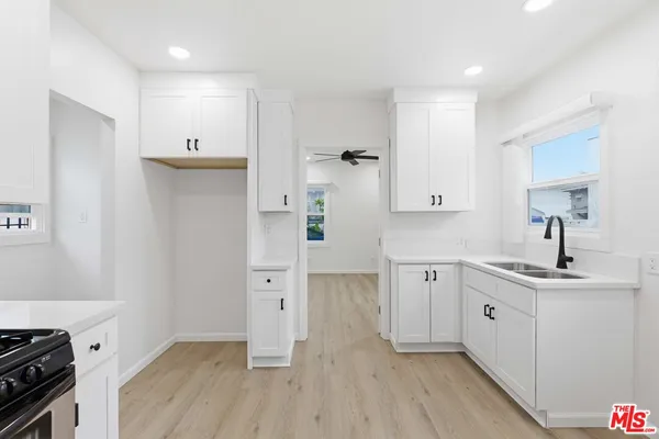 a kitchen with cabinets and wooden floor
