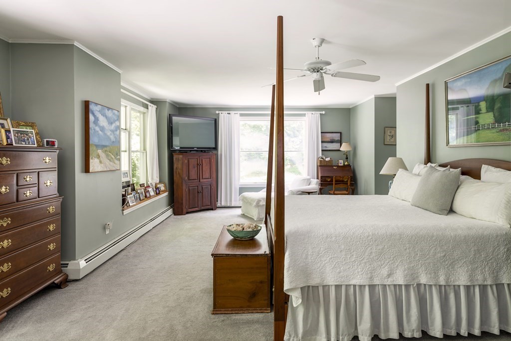 21 Mill Road Ipswich, MA 01938 - Photo 13 of 23 a bedroom with a large bed and a chandelier