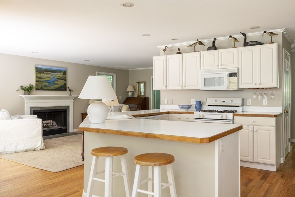 21 Mill Road Ipswich, MA 01938 - Photo 10 of 23 a kitchen with a stove a sink a refrigerator and white cabinets with wooden floor