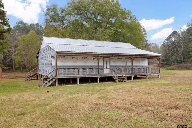 a view of a house with backyard and a tree