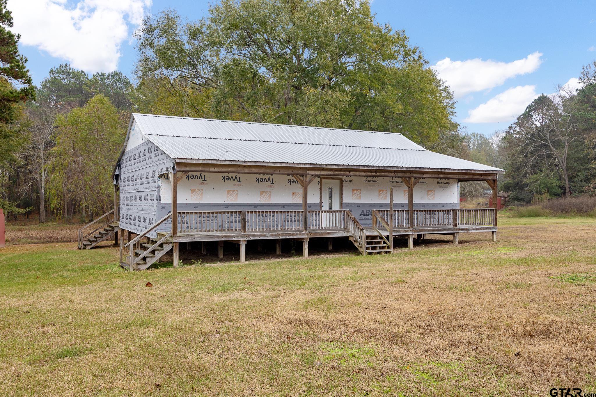 a view of a house with backyard and a tree