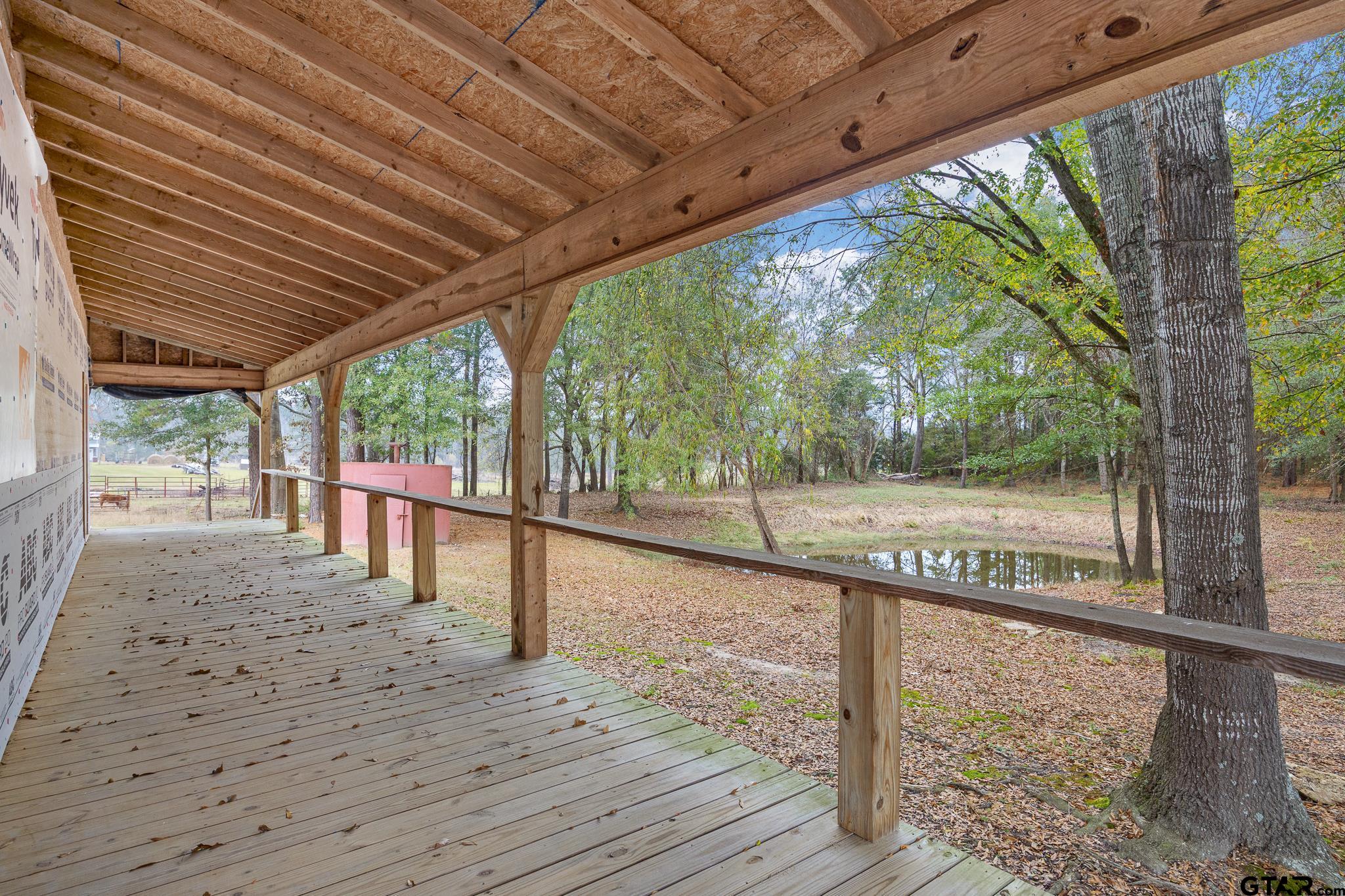 11063 County Road 2298 Tyler, TX 75707 - Photo 15 of 21 a view of a porch with wooden floor and roof with a garden view