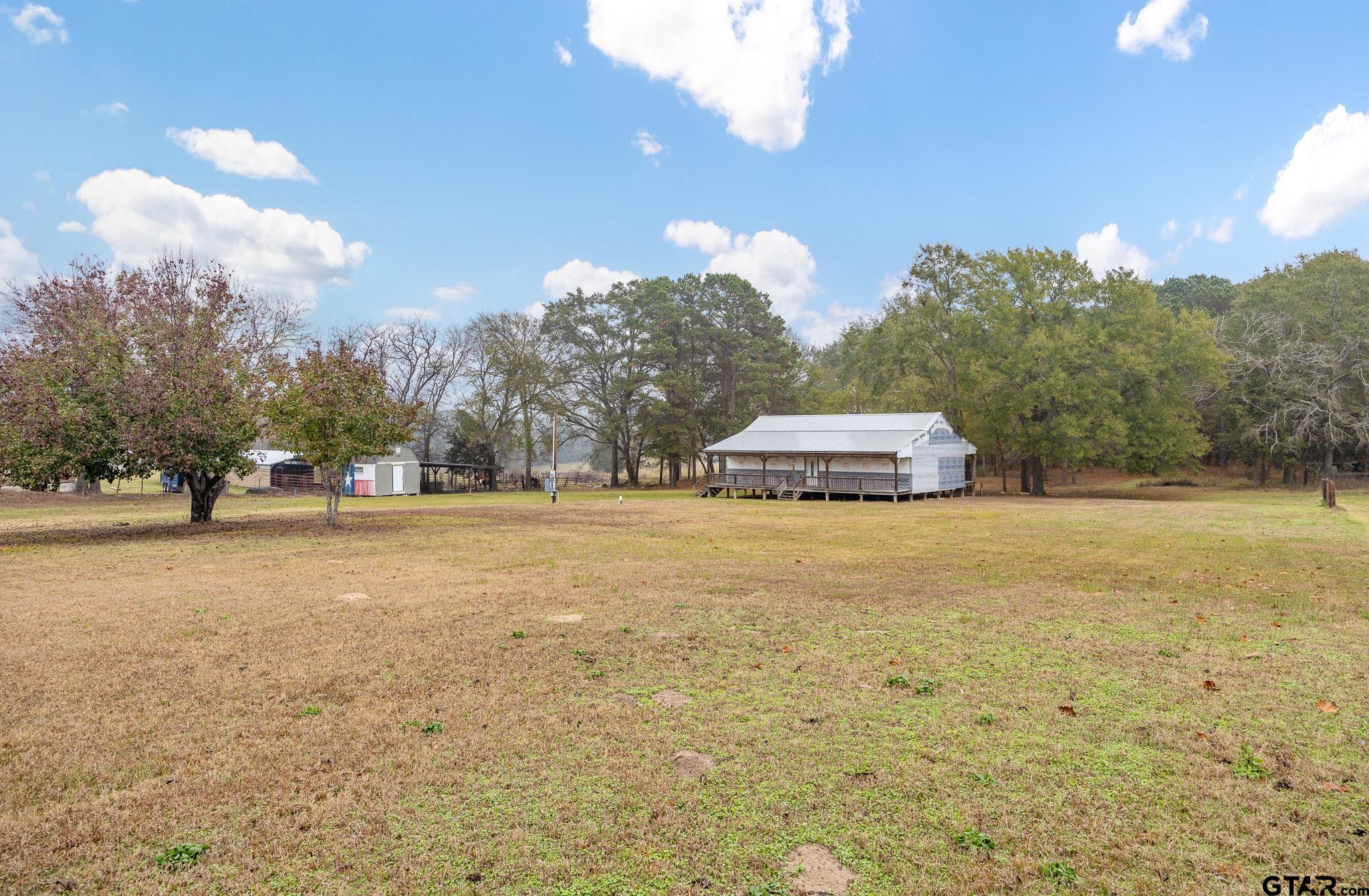 11063 County Road 2298 Tyler, TX 75707 - Photo 4 of 21 a tall yellow house with trees in front of it