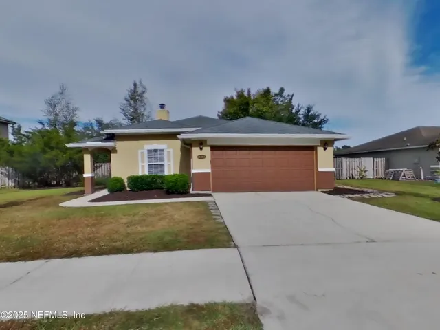 a front view of a house with a yard and a garage
