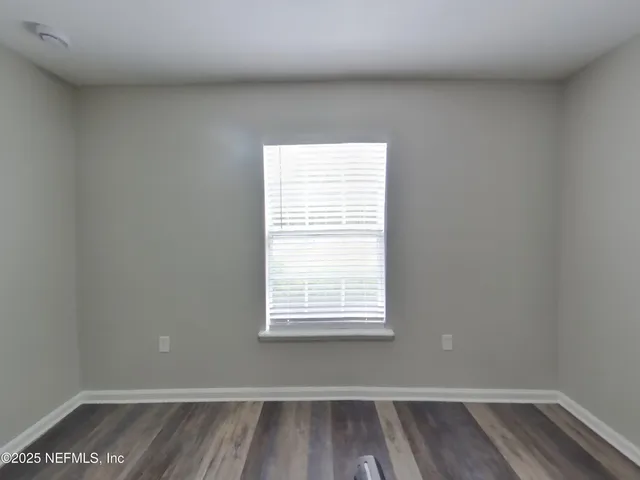 a view of a small space with wooden floor and a window