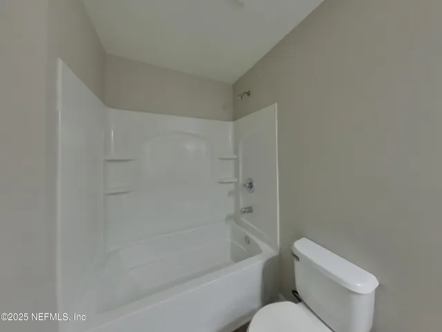 a white toilet sitting next to a bath tub