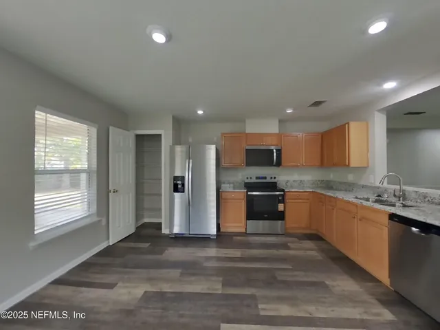 a kitchen with stainless steel appliances kitchen island granite countertop a stove and a sink