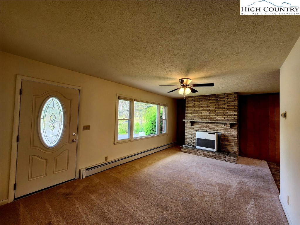 130 Wheeler Street Boone, NC 28607 - Photo 23 of 40 an empty room with windows fireplace and fans