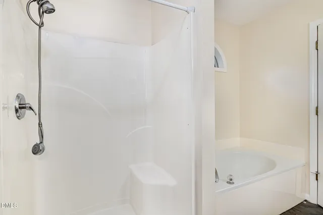 an empty room with a window and ceiling fan