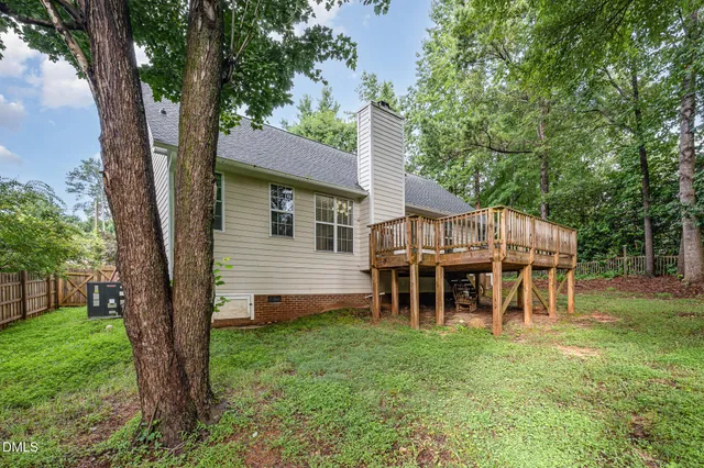 a view of a chair and table in backyard of the house