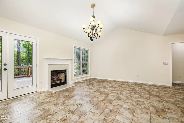 a view of empty room with fireplace and windows