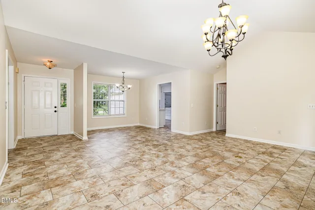 a view of a big room with a chandelier fan and windows