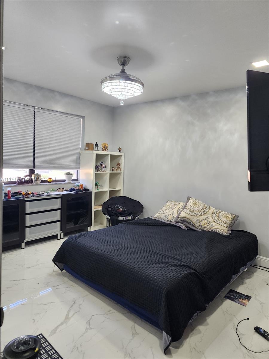 10046 Winding Lake Road, Unit 201 Sunrise, FL 33351 - Photo 11 of 12 a bedroom with bed and a chandelier