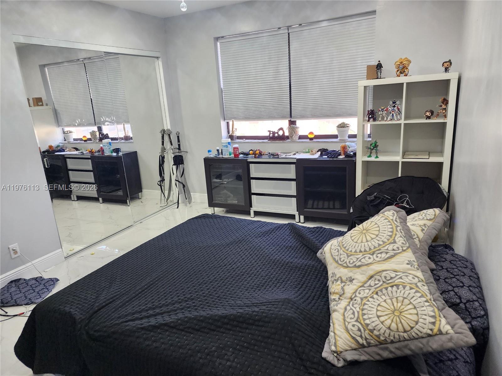 10046 Winding Lake Road, Unit 201 Sunrise, FL 33351 - Photo 12 of 12 a bedroom with a bed and a mirror