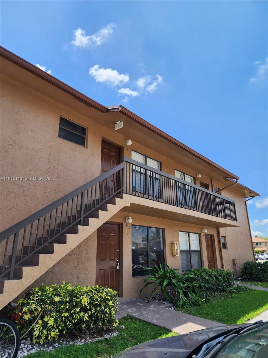 10046 Winding Lake Road, Unit 201 Sunrise, FL 33351 - Photo 2 of 12 a front view of a house with a yard