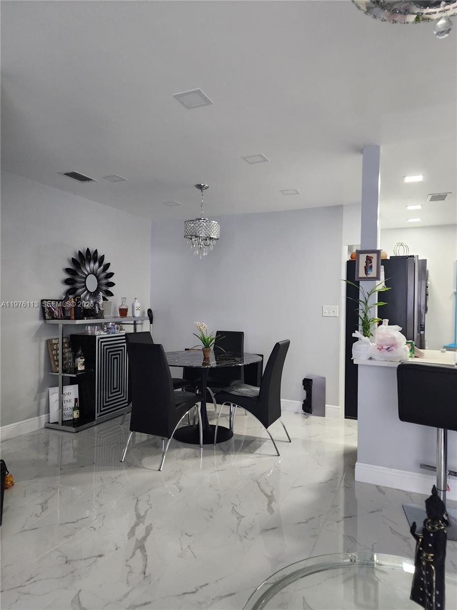 10046 Winding Lake Road, Unit 201 Sunrise, FL 33351 - Photo 8 of 12 a living room with furniture a dining table and a fireplace