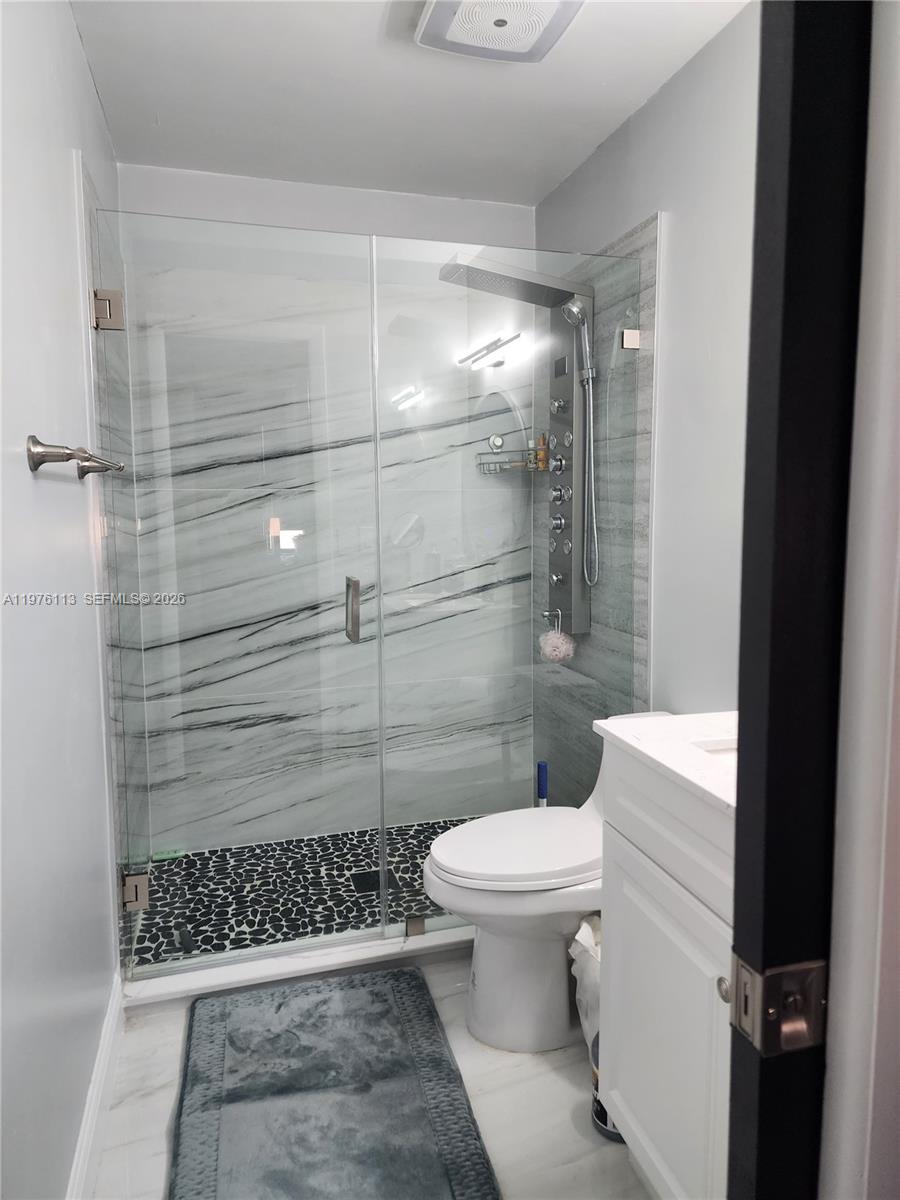 10046 Winding Lake Road, Unit 201 Sunrise, FL 33351 - Photo 9 of 12 a bathroom with a toilet and a shower