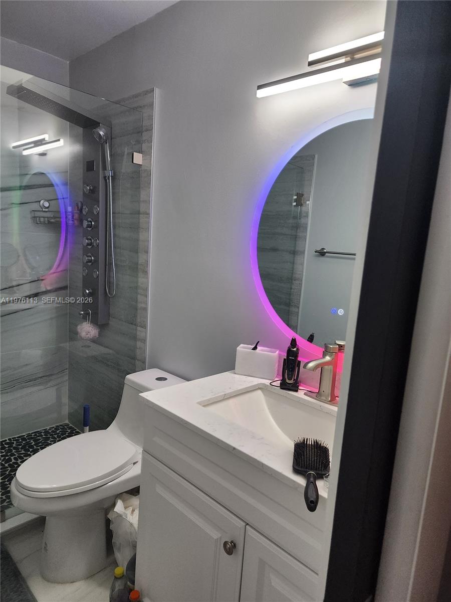 10046 Winding Lake Road, Unit 201 Sunrise, FL 33351 - Photo 10 of 12 a bathroom with a sink mirror and toilet