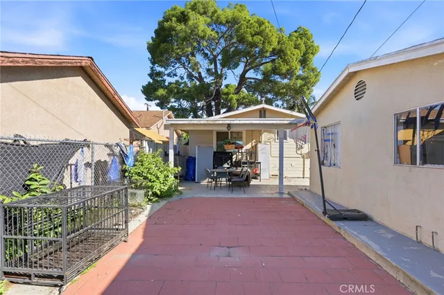 a view of a patio with a table and chairs under an umbrella