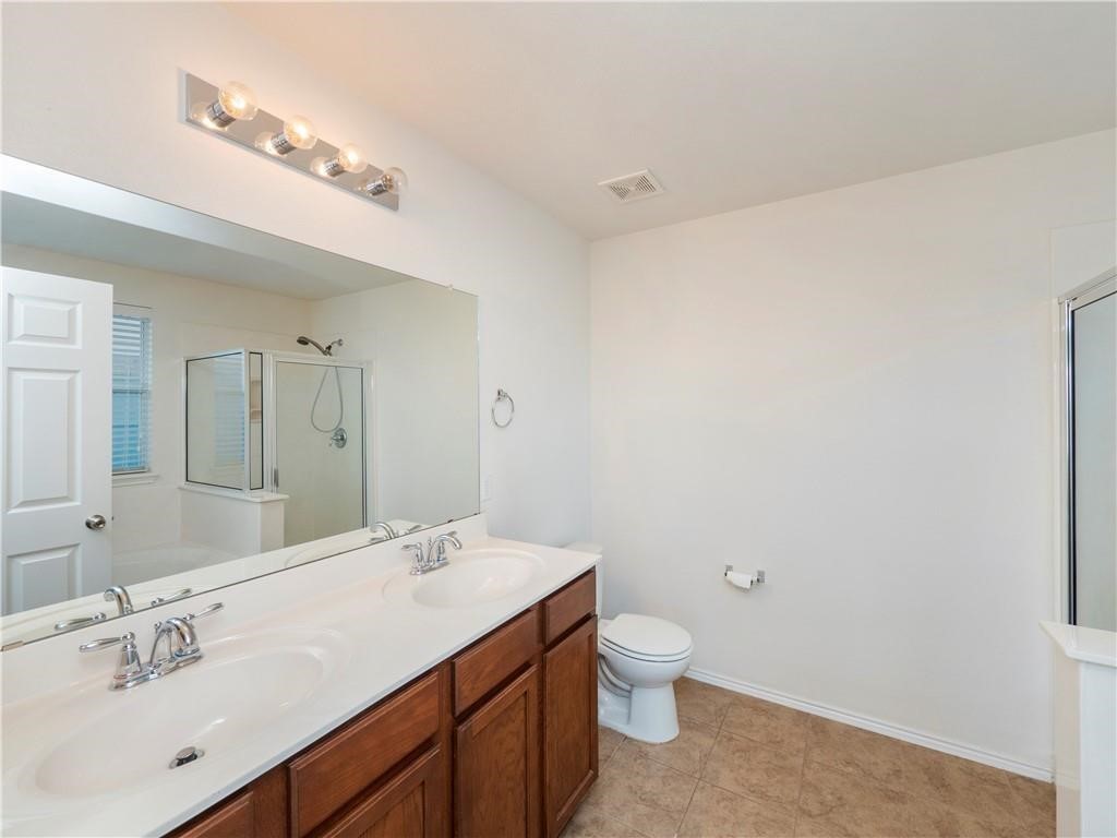 120 Inca Dove Lane Leander, TX 78641 - Photo 13 of 15 a bathroom with a granite countertop sink a toilet and a mirror