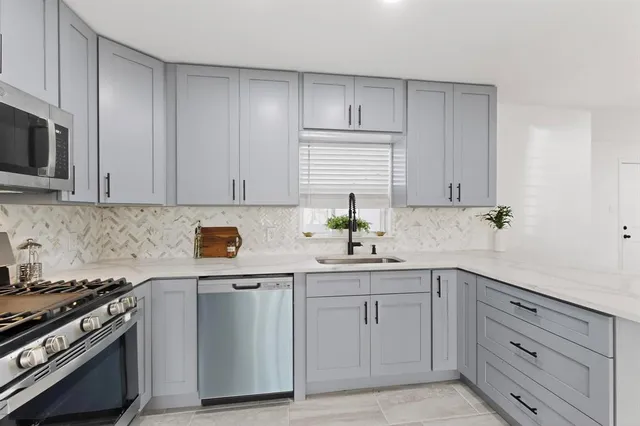 a kitchen with white cabinets and appliances