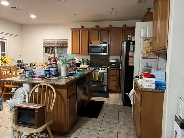 a kitchen with kitchen island a counter top space a sink a stove and a refrigerator