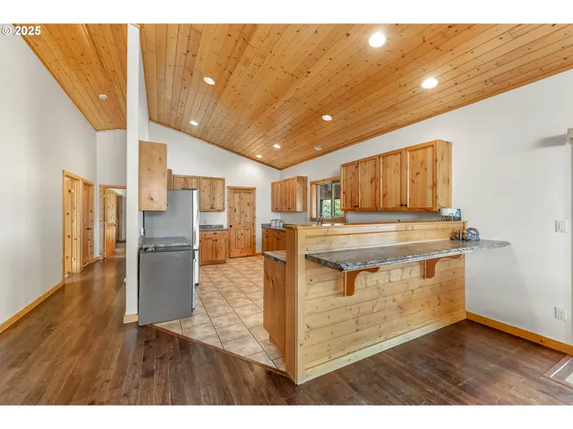 a kitchen with granite countertop a stove a sink dishwasher and a refrigerator