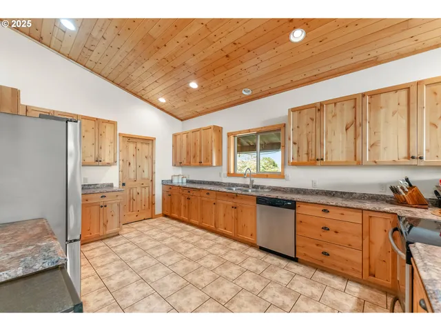 a kitchen with granite countertop a refrigerator stove top oven and sink