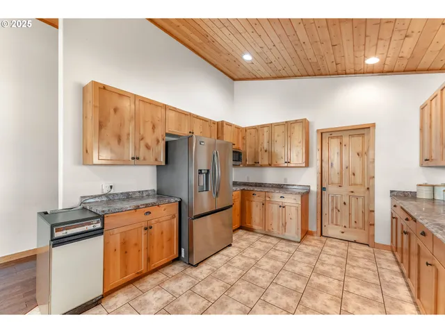a open kitchen with granite countertop a sink dishwasher stove and cabinets