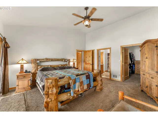 a bed sitting in a spacious bedroom next to a window