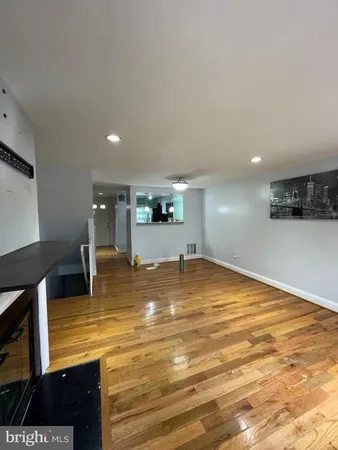 a view of empty room with wooden floor and fireplace