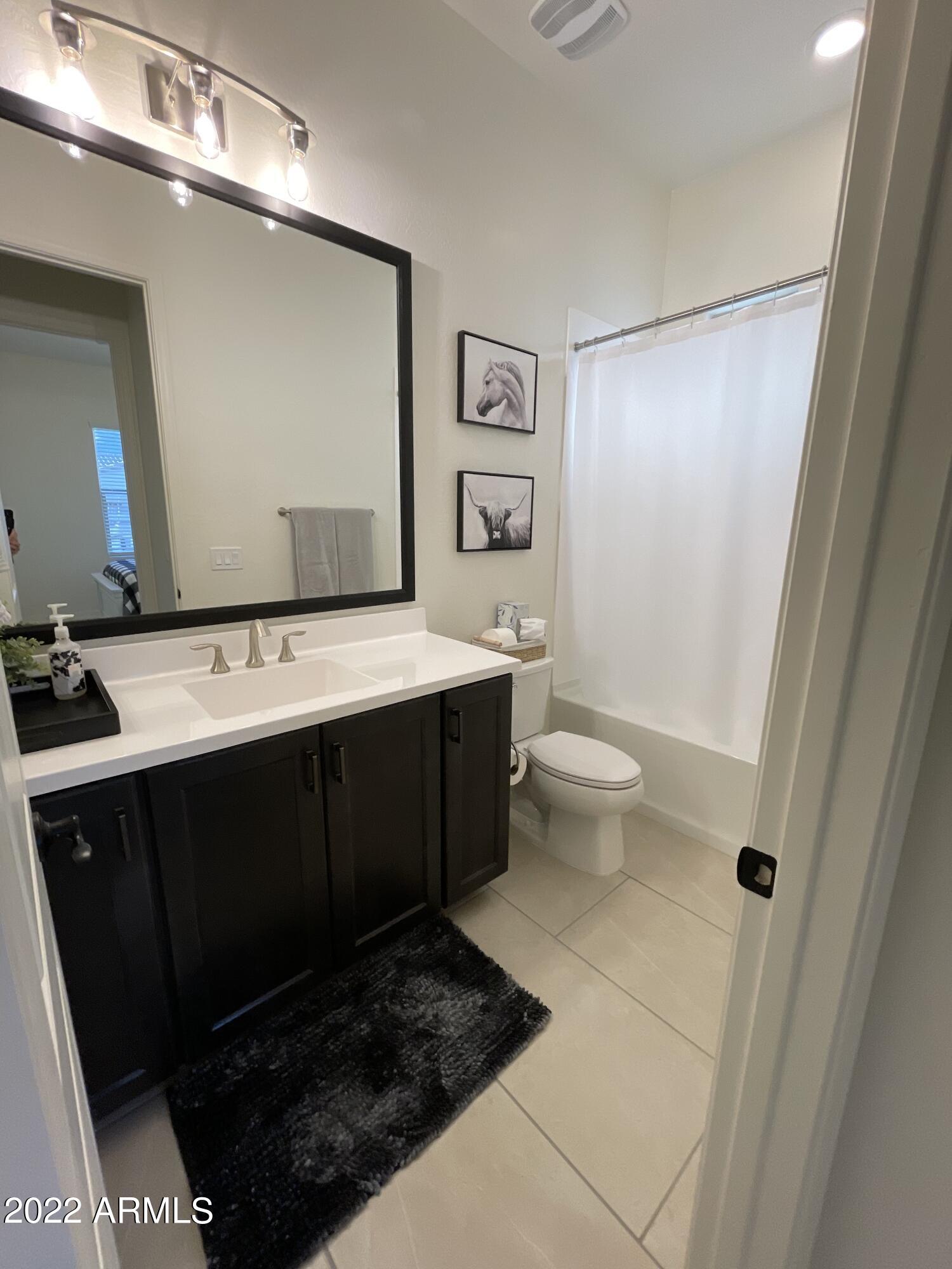 38500 North School House Road, Unit 50 Cave Creek, AZ 85331 - Photo 11 of 17 a bathroom with a sink a toilet a mirror and shower