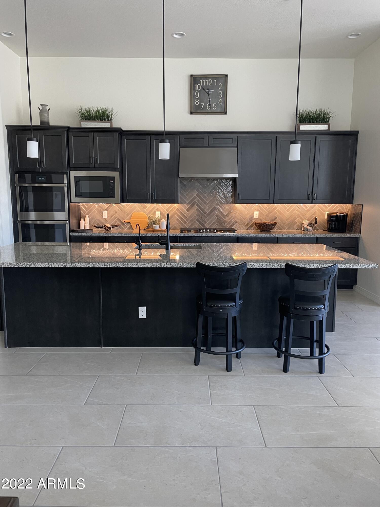 38500 North School House Road, Unit 50 Cave Creek, AZ 85331 - Photo 2 of 17 a kitchen with stainless steel appliances granite countertop a table chairs sink and wooden cabinets