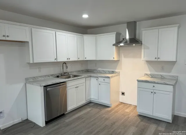 a kitchen with granite countertop cabinets stainless steel appliances and a sink