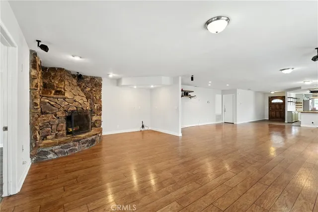 wooden floor in an empty room with a kitchen