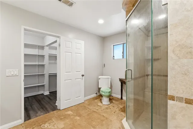 a spacious bathroom with a toilet and a shower