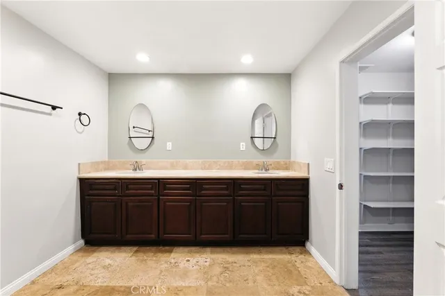 a bathroom with a granite countertop double vanity sink and a mirror