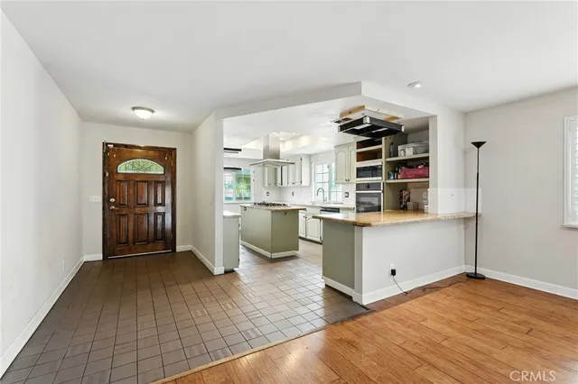 a kitchen with a refrigerator and white cabinets