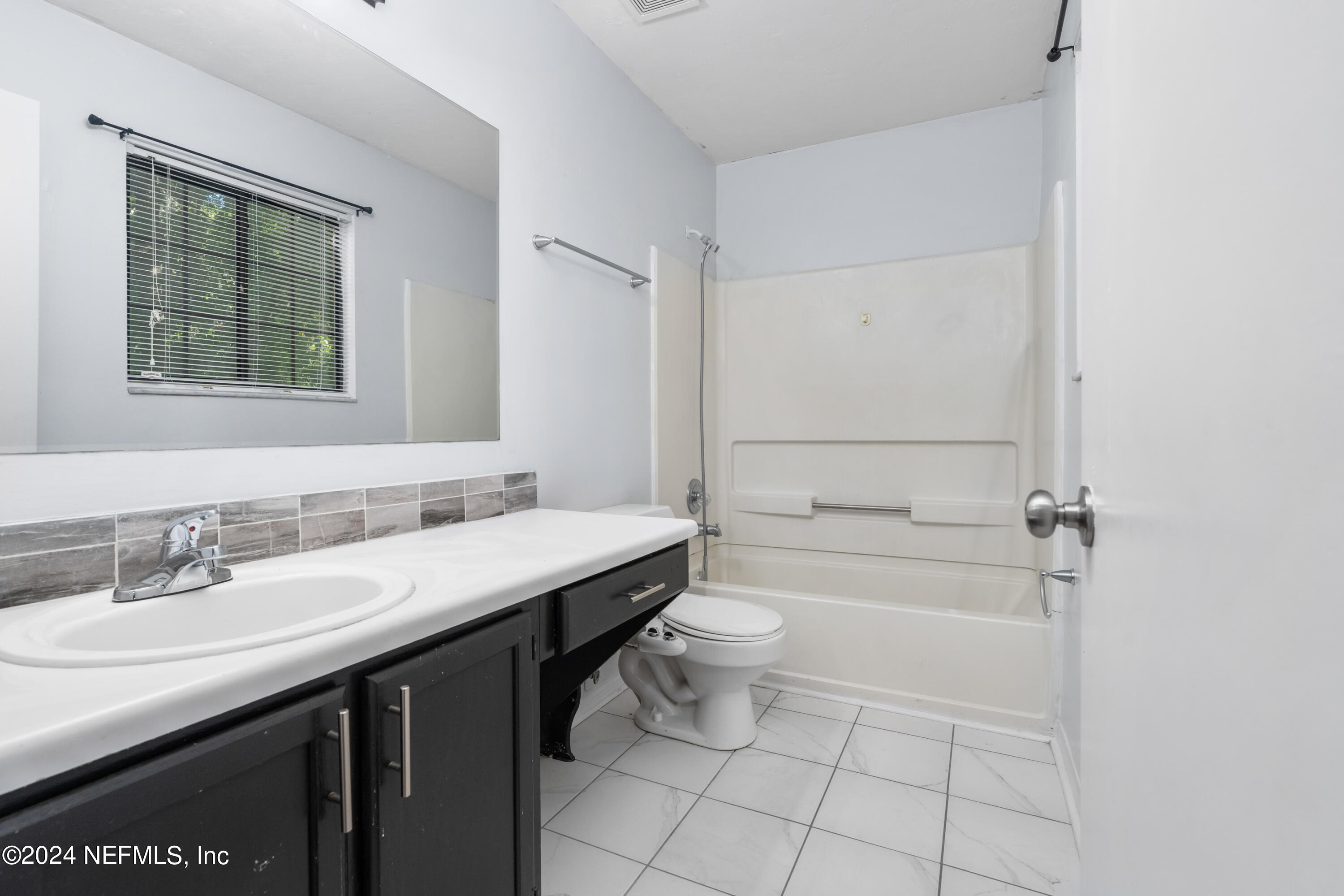5720 Southwest 8th Place Gainesville, FL 32607 - Photo 12 of 17 a bathroom with a granite countertop sink a toilet and bathtub