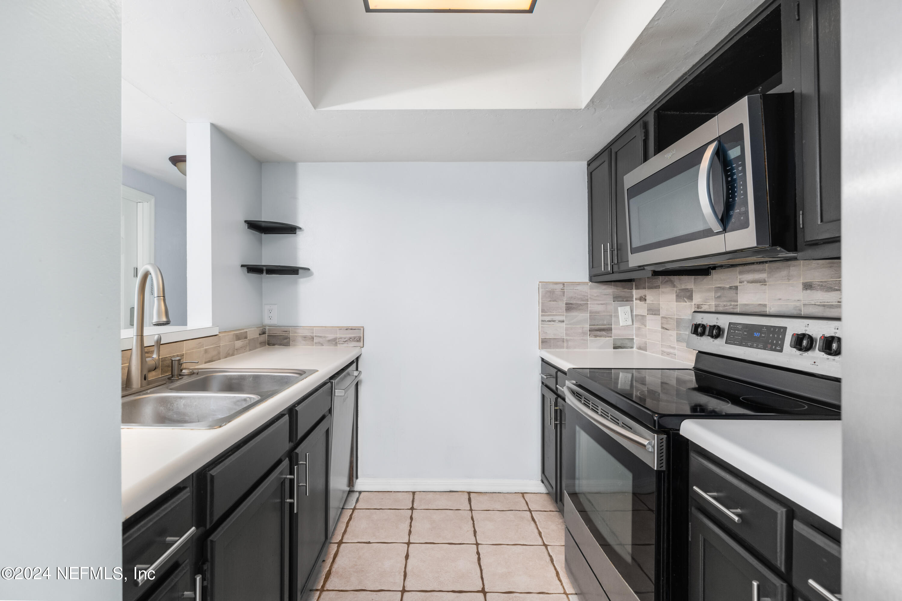 5720 Southwest 8th Place Gainesville, FL 32607 - Photo 6 of 17 a kitchen with stainless steel appliances granite countertop a sink stove and microwave
