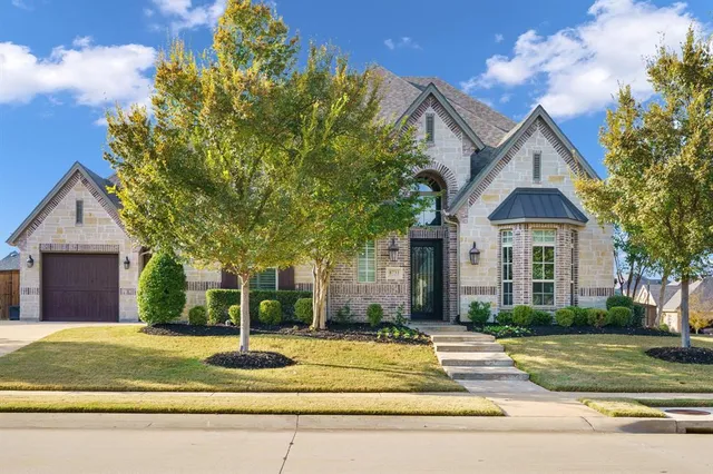 a view of a house with a yard and large tree