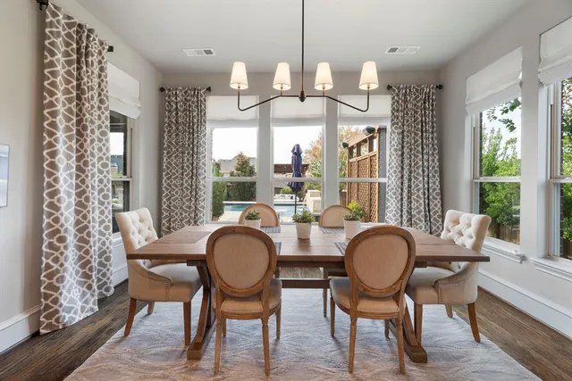 a dining room with furniture a chandelier and wooden floor