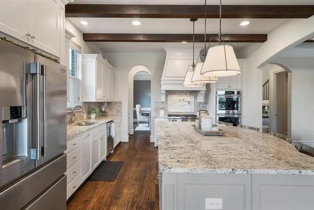 a large kitchen with kitchen island a large counter space a sink appliances and cabinets