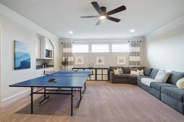 a living room with furniture a rug kitchen view and a chandelier