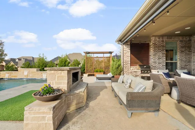 a view of a patio with couches potted plants and a big yard