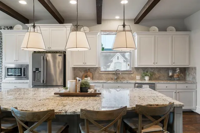 a kitchen with granite countertop a table chairs stove and cabinets